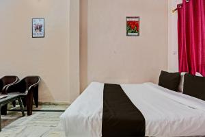 a bedroom with a bed with a red curtain at OYO Hotel Trishakti Homestay in Lucknow