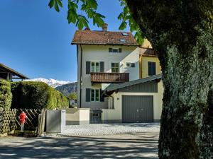 une maison blanche avec un toit marron et un garage dans l'établissement Alpenwelt III, à Garmisch-Partenkirchen