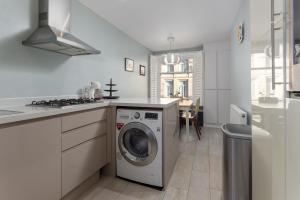a white kitchen with a washing machine in it at Flatzy - 3 Bedroom Apartment in Heart of City Centre in Liverpool