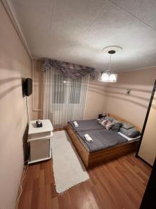 a small bedroom with a bed and a window at Atomcity Apartman in Paks