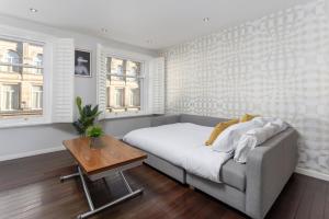 a bedroom with a bed and a table and windows at Flatzy - 3 Bedroom Apartment in Heart of City Centre in Liverpool