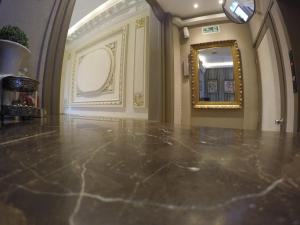 a hallway with a marble floor and a mirror at New Arapey Hotel in Montevideo