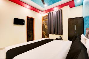 a bedroom with a white bed and a tv at Flagship Hotel RAAS INN in Kānpur