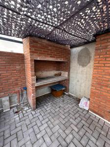 a brick wall with a bench on a patio at Depto moderno, Barrio Martín in Rosario