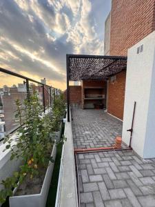 un balcón de un edificio de ladrillo con plantas. en Depto moderno, Barrio Martín en Rosario