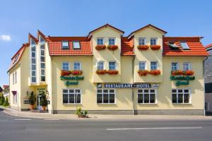 un gran edificio amarillo con flores en las ventanas en DM Hotes & Apartments - Apartment Dosborn 5-9, en Dingelstädt