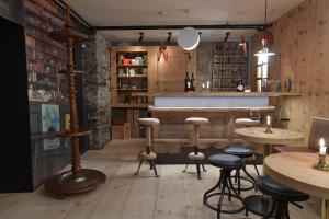 a bar with stools and tables in a room at Casa Fausta Capaul in Brigels