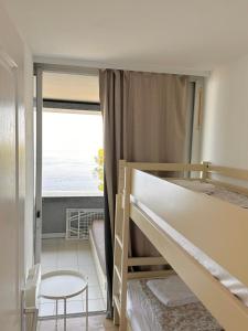 RIVIERA Appart'hôtel Panoramique في كاب دايل: غرفة نوم مع سرير بطابقين مع إطلالة على المحيط