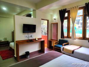 een hotelkamer met een bed en een tv en een kamer bij Aurora Gangtok in Gangtok +26 foto's
