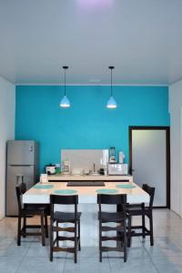 a kitchen with a table and chairs and a blue wall at Cahuita Apartment by Angie in Cahuita