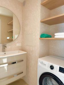 a bathroom with a washing machine and a sink at RIVIERA Appart'hôtel Panoramique in Cap d'Ail