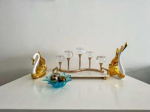 a table with a plate with wine glasses and a mermaid at Queens&Kings Garden in Nairobi