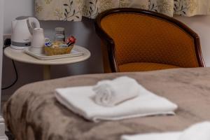 a white towel sitting on the edge of a bed at Beechwood Accommodation in North Leeds in Leeds