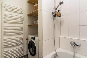 a bathroom with a washing machine and a shower at Am Wii- Weg in Vogtsburg