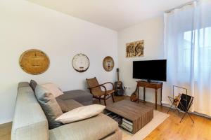 a living room with a couch and a flat screen tv at Am Wii- Weg in Vogtsburg