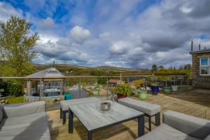 a patio with a table and chairs on a deck at Cosy Cabin Perfect To Explore in Garnant