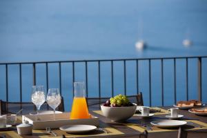 シヴォタにあるVilla Kastos - Stylish Luxury Villa with Direct Sea Accessのテーブル(フルーツボウルとワイングラス付)
