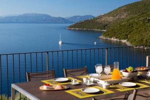 シヴォタにあるVilla Kastos - Stylish Luxury Villa with Direct Sea Accessの水辺の景色を望むダイニングテーブル
