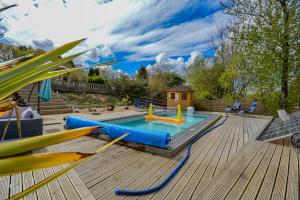 a pool with two inflatables on a wooden deck at Cosy Cabin Perfect To Explore in Garnant