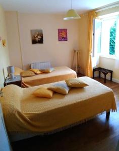 a bedroom with two beds and a window at Cottage by the Chateau with pool in National Parc in Les Salles-Lavauguyon