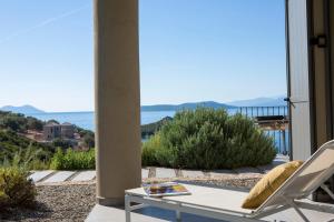 Un patio con mesa y sillas y el mar. en Villa Kastos - Stylish Luxury Villa with Direct Sea Access, en Sivota 37 fotos más