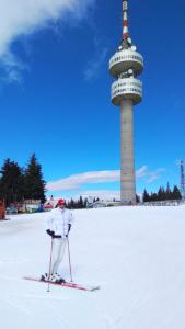 una persona esquiando en la nieve frente a una torre en Ски Апартамент 4а26 Grand Monastery en Smolyan