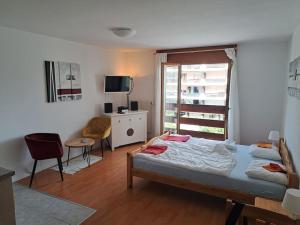 a bedroom with a bed and a desk and a window at Torgon Grand studio Confortable in Torgon