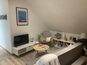 uma sala de estar com um sofá e uma televisão em Agréable chambres d’hôte em Parence