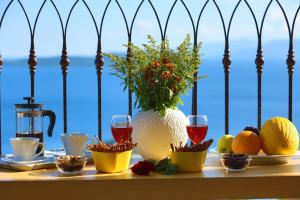 una mesa con copas de fruta y vino y un jarrón de flores en Villa Columba - Luxury Private Villa in Modern Residence, en Sivota