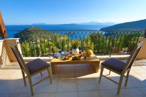 a table and chairs on a balcony with a view of the ocean at Villa Columba - Luxury Private Villa in Modern Residence in Sivota