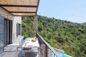 a balcony with a table and a view of a mountain at VILLAS MIRO - Luxury Villas with Direct Sea Access for 14 people in Sivota