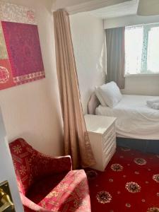 niewielka sypialnia z łóżkiem i krzesłem w obiekcie Bella Vista w mieście Llandudno