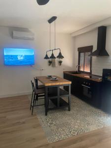 a dining room with a table and a tv at Río Genil in Pinos Genil