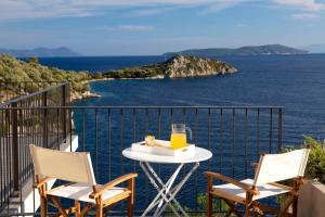 Una mesa con una bandeja de jugo de naranja y dos sillas. en Villa Kalamos - Modern Villa in Sivota Bay with Direct Access to Sea, en Sivota