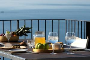 una mesa con comida y copas de vino en el balcón en Villa Kalamos - Modern Villa in Sivota Bay with Direct Access to Sea, en Sivota 34 fotos más