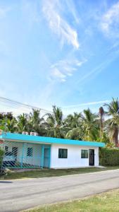a blue and white building with palm trees in the background at Cahuita Apartment by Angie in Cahuita