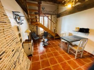 a dining room with a table and a brick floor at Appart' d'hôtes , ch et gîte au Manoir de la Haute Pilais in Chantepie