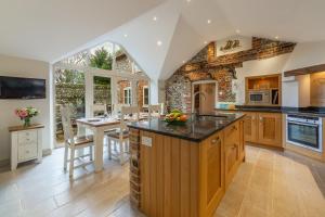 an open kitchen with a large island and a dining area at Mayes Cottage in Brancaster