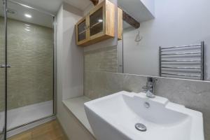 a bathroom with a sink and a shower at Mayes Cottage in Brancaster +20 photos