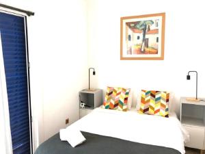 una camera bianca con un letto e una finestra di The Albufeira Concierge - Moinho Pool & Gardens ad Albufeira