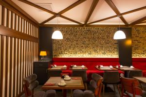 een restaurant met tafels en stoelen en een bakstenen muur bij Hotel Favori Nisantasi in Istanbul