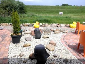un jardín con estatuas de patos y rocas de goma en Apartment am Elberadweg, en Damnatz