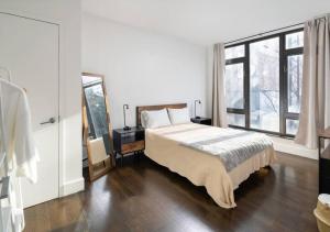 a bedroom with a bed and a large window at Stunning One Bed One Bath At UES in New York