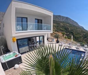 een huis met een balkon en een zwembad bij New! Luxury Boutique Villa Fay, heated Pool, Jacuzzi, Seaview near Split and Omis in Dugi Rat