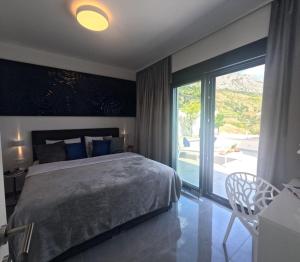 een slaapkamer met een groot bed en een glazen schuifdeur bij New! Luxury Boutique Villa Fay, heated Pool, Jacuzzi, Seaview near Split and Omis in Dugi Rat
