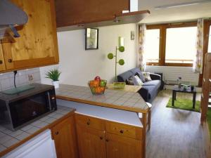 a kitchen and a living room with a couch at Studio 4 pers, Balcon Sud, Lave-vaisselle, Animaux acceptés - FR-1-404-62 in La Mongie