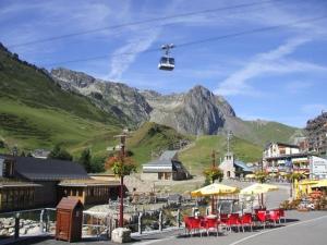 a chair lift flying over a town with a mountain at Studio 4 pers, Balcon Sud, Lave-vaisselle, Animaux acceptés - FR-1-404-62 in La Mongie +13 photos