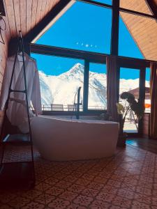 bañera en una habitación con vistas a la montaña en Kera cottages kazbegi, en Kazbegi