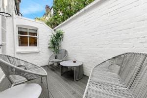 two chairs and a table on a wooden deck at Mayfair Apartment with Private Terrace! in London