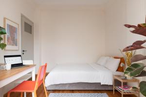 Schlafzimmer mit einem Bett und einem Schreibtisch mit einem Laptop in der Unterkunft Studio with sunny balcony in Exarcheia in Athen